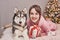 Girl with dog husky on Christmas background. Christmas card template. Family christmas. Merry christmas and happy new year concept