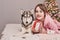 Girl with dog husky on Christmas background. Christmas card template. Family christmas. Merry christmas and happy new year concept