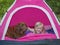 Girl with dog in pink tent camping, hiking photo