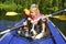 A girl with a dog sitting in a kayak on the lake