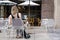 Girl with dog is sitting at table in cafe