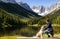 Girl and Dog Walking through Scenic Landscape of Meadows, Valleys, Mountains, and Lakes