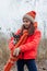 Girl and dog in winter outfits. Teenager girl in an orange jacket, hat and scarf. Girl and chihuahua