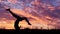 Girl doing acrobatic element at sunset. Slow motion.