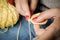 Girl doing crochet with yellow yarn and nails painted red