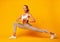 Girl Doing Deep Lunge Exercise Over Yellow Background