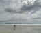 Girl doing exercises, empty beach under a stormy sky, New Zealand