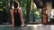 Girl doing Koundinyasana, then young woman out of asana position and sits down on yoga mat alone. Working out on wooden