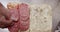 Girl doing sandwich with salami. Puts sausage on bread. Slow motion Top view