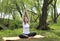 Girl doing yoga on the Mat in a clearing in nature ,a woman in a Lotus position