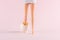 Girl doll leg in cracked Easter egg on pastel pink background. Easter minimal concept. Creative Happy Easter or spring layout