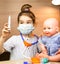 A girl with a doll plays doctor, makes a syringe inoculation in the hand. Vaccination, vaccination calendar, vaccine, profession