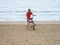 Girl drags a bicycle on the sand at the seaside