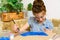 A girl drawing blue gouache cardboard, artistic creation at home, makes creative artwork