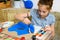 A girl drawing blue gouache cardboard, artistic creation at home, makes creative artwork