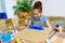 A girl drawing blue gouache cardboard, artistic creation at home, makes creative artwork