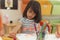 Girl drawing color pencils in kindergarten classroom, preschool and kid education concept.
