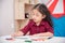 Girl drawing picture by color marker on table
