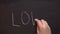 The girl draws on a blackboard \'love\' chalk. drawing chalk.