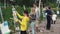 Girl draws picture on easel in green park on summer festival among other people