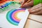 Girl draws a rainbow. Positive drawing. Art therapy and relaxation.