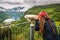 Girl with dreadlocks looks at the fjord through binoculars