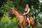 Girl in dress and brown horse portrait in forest