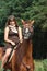 Girl in dress and brown horse portrait in forest