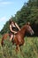 Girl in dress and brown horse portrait in forest