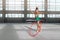 Girl in dress dancing with hoop gym-hall
