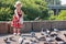 Girl in dress feeding pigeons