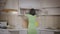 Girl in a dress puts things in order in the kitchen cabinet, arranges the dishes, rear view