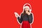 Girl in dress surprise showing product. emotional girl in santa claus christmas hat Magazine collage style with trendy color