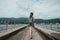 Girl in the dress is walking on the pier. Back view. Dyed hair