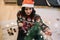 Girl dressed with Christmas sweater decorating tree with lights