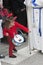 Girl dressed in red with a toy drum looking in front of a Nazarene