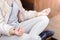 A girl dressed in style casual sits in a lotus position in a city location