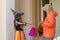 Girl dressed in a witch costume asks an senior woman for candy at Halloween day.