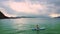 Girl drifts on paddleboard in pose Half Lotus among ocean