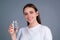 Girl drinking water, isolated on studio background. Young woman enjoy pure fresh mineral water. Thirsty woman hold glass