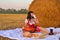 A girl drinks milk on a hayloft