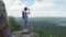 The girl drinks water on peak of the mountain after a long journey to the top.