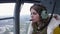 Girl in earphones with microphone seat flying helicopter. Noise. Transportation. Above ground
