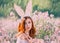 Girl easter bunny with creative ears on the hoop. Portrait of a young, red-haired woman with big beautiful eyes and lips