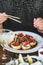 Girl eating baked susi maki with chopsticks at Japanese restaurant