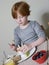 Girl Eating Boiled Egg At Dining Table