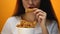 Girl eating chicken wings, high calorie food and health risks, cholesterol