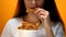 Girl eating chicken wings, high calorie food and health risks, cholesterol