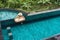 Girl eating floating breakfast in luxury hotel pool