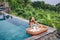 Girl eating floating breakfast in luxury infinity pool